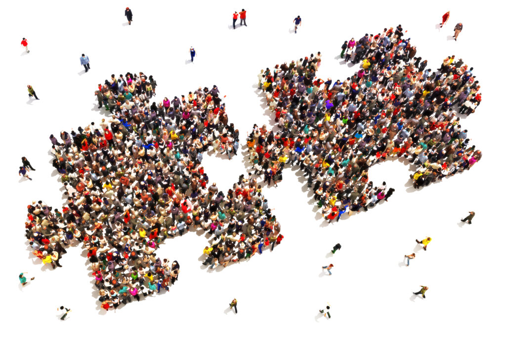 Large group of people in the shape of two puzzle pieces on a white background.